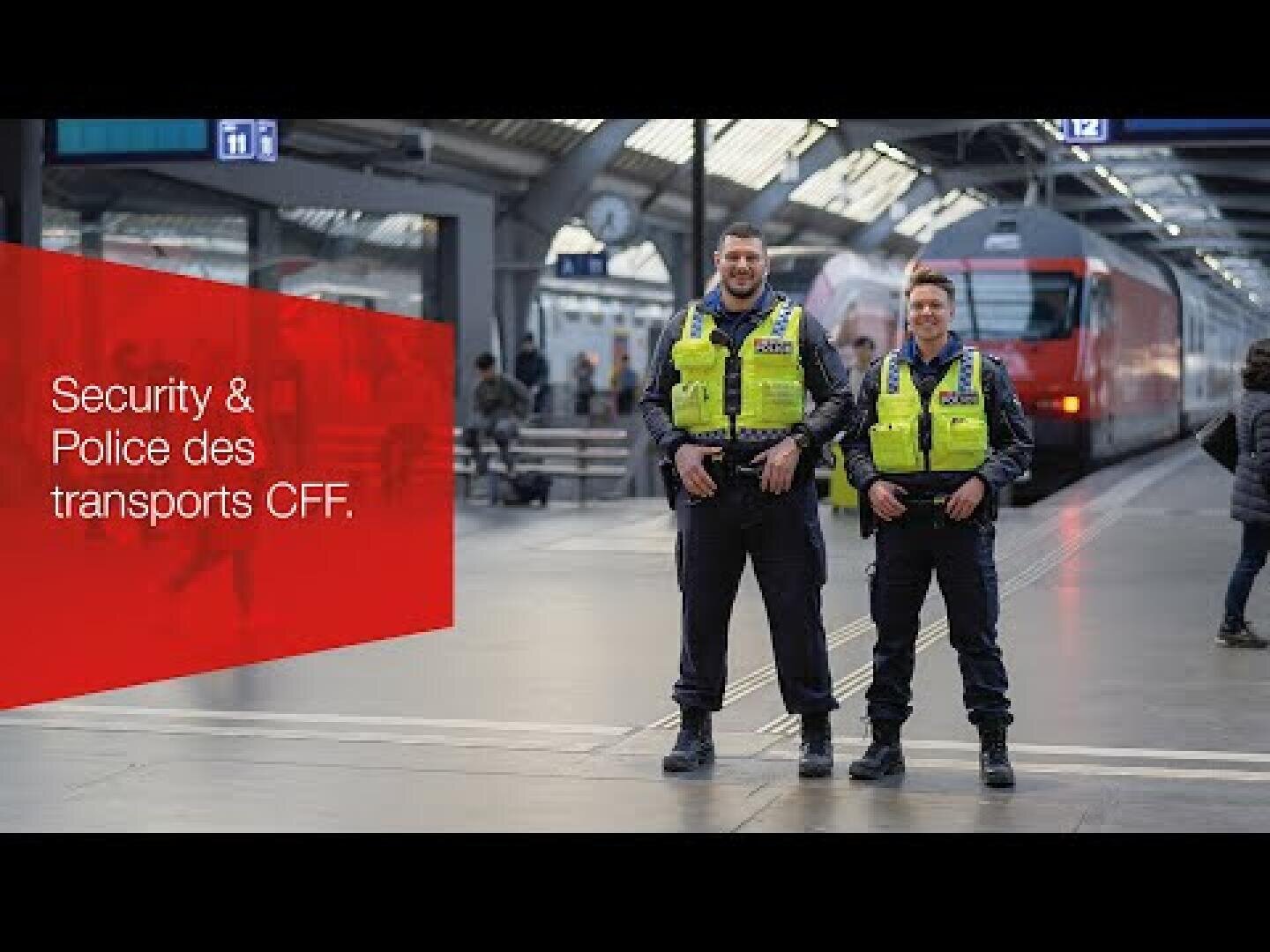Deux agents de la police des transports en uniforme sourient sur un quai de gare à l'intérieur d'une gare moderne, avec un train rouge et des passagers en arrière-plan. Une zone de texte rouge indique "Security & Police des transports CFF".