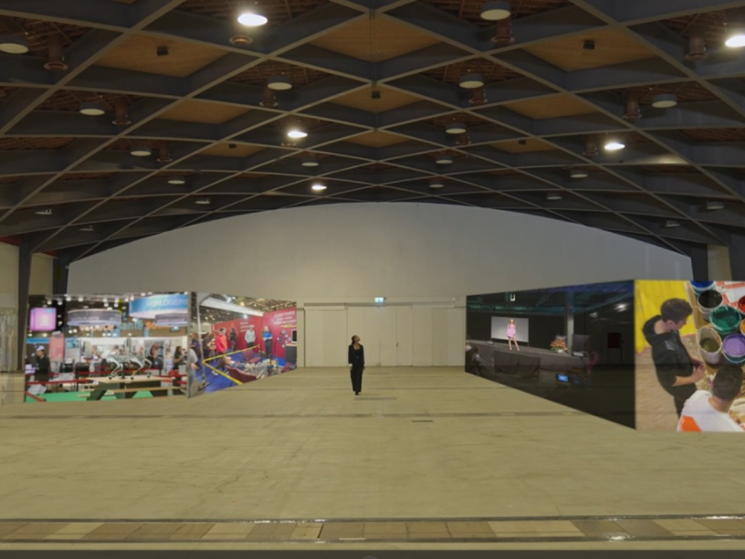 Une personne se trouve dans un grand hall vide. Sur le mur du fond, trois grands panneaux colorés présentent diverses scènes d'art et d'activité. Le plafond est géométrique avec des poutres apparentes.